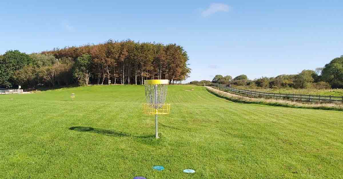 Disc golf baskets in awell-mown field