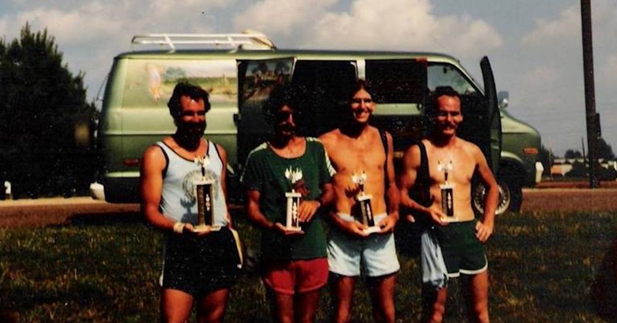 Photo from the late 70s of young men standing in front of a green van and holding trophies