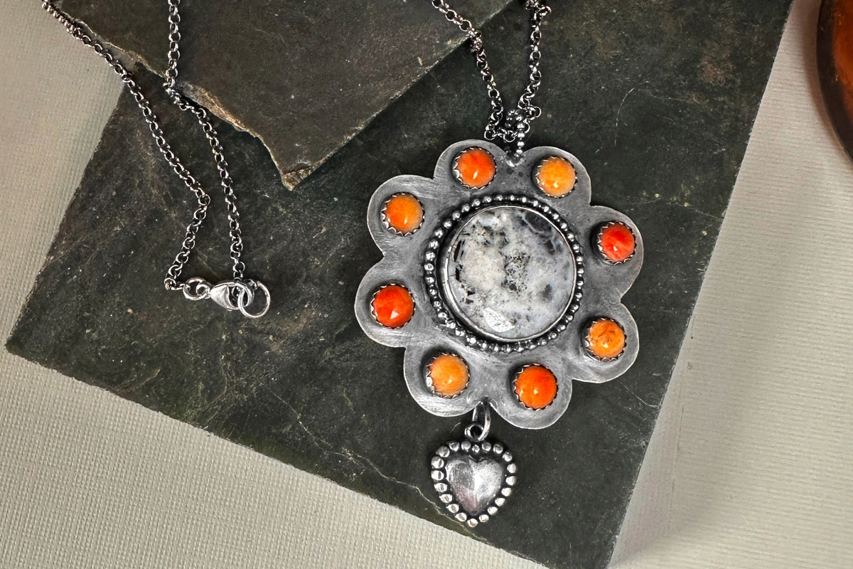 white buffalo southwestern pendant with spiny oyster around it, flower shaped, with a heart dangle