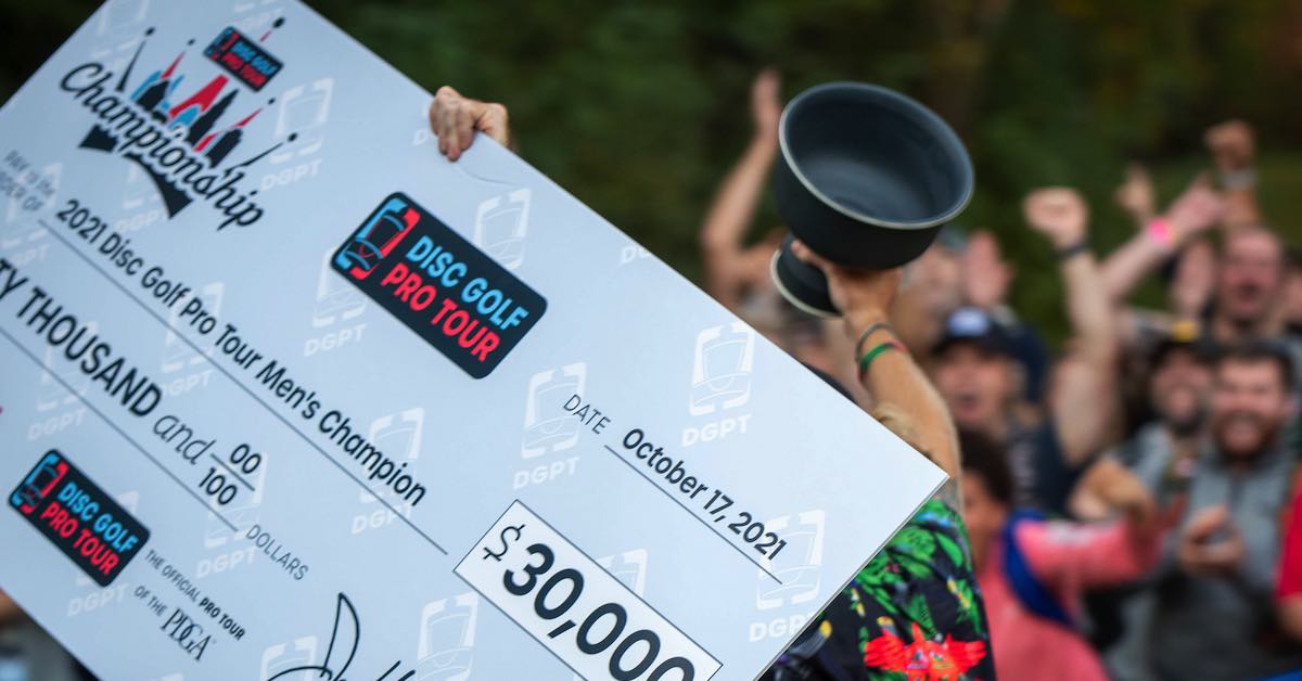 A large check and a trophy being held up in front of a crowd