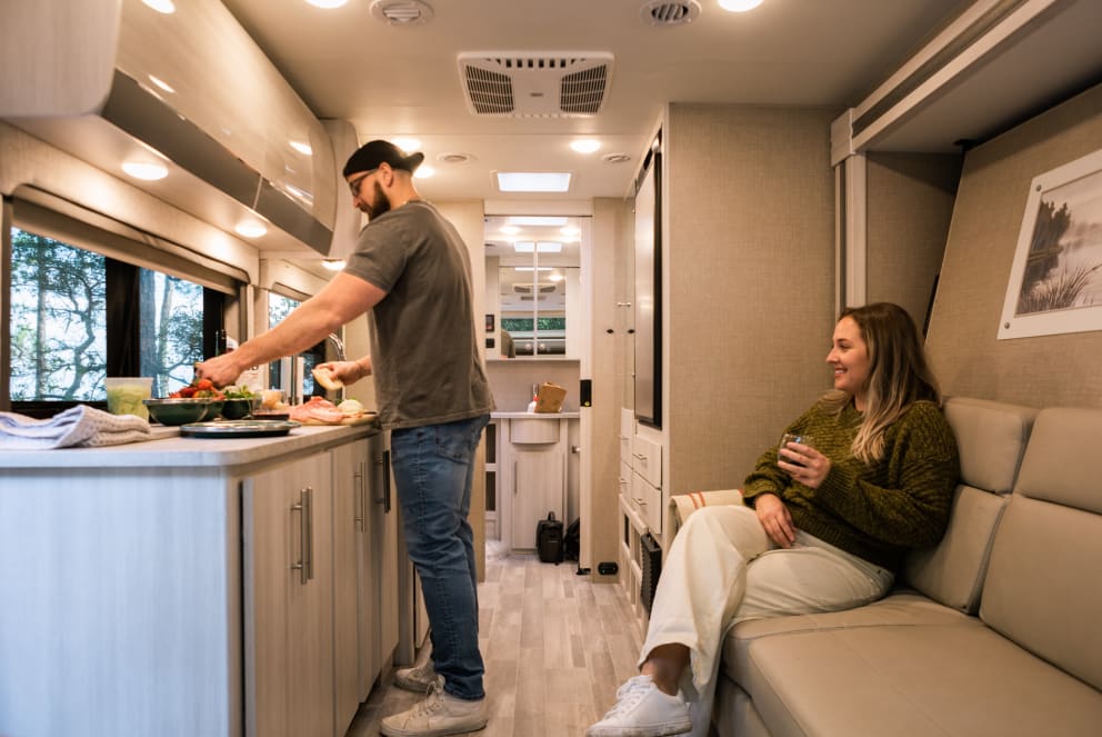 couple cooking dinner inside RV