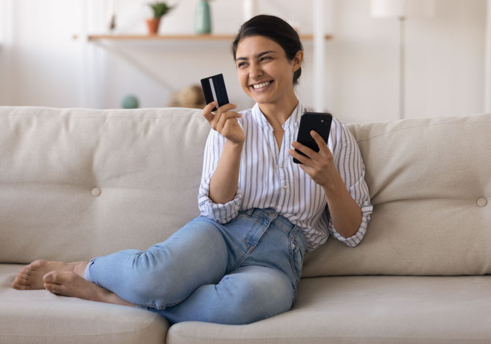 woman on couch and happy from borrowing money and get a payday loan instantly