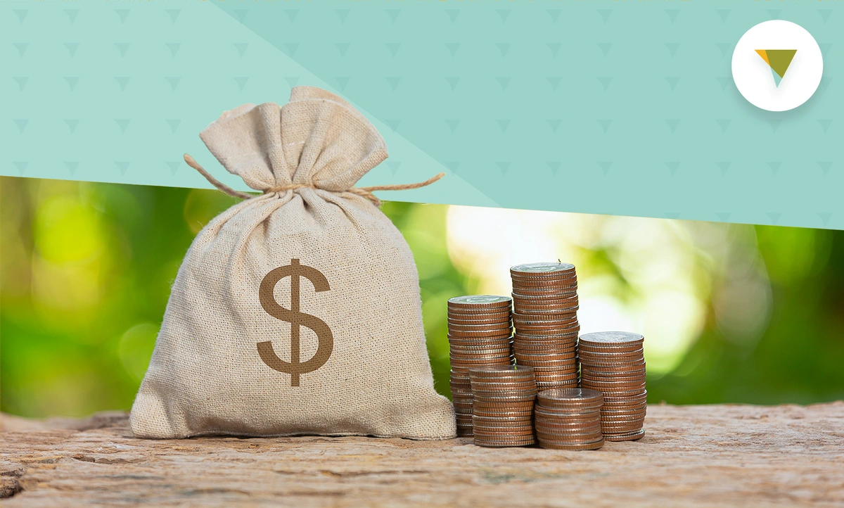 A bag of money with stack of coins beside it.