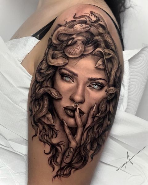 blue eyed medusa tattoo on the upper arm