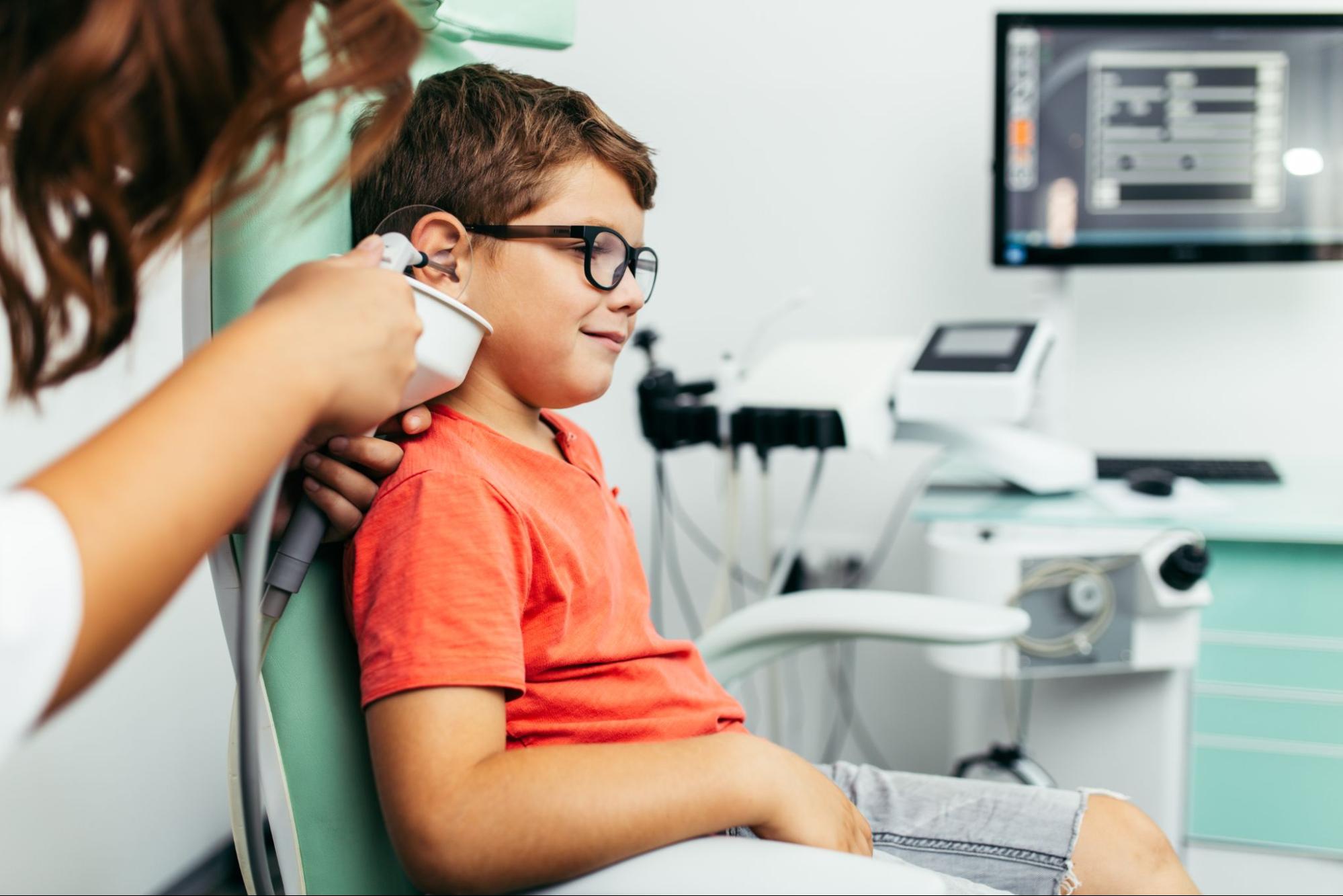 Boy getting his ears cleaned by a doctor