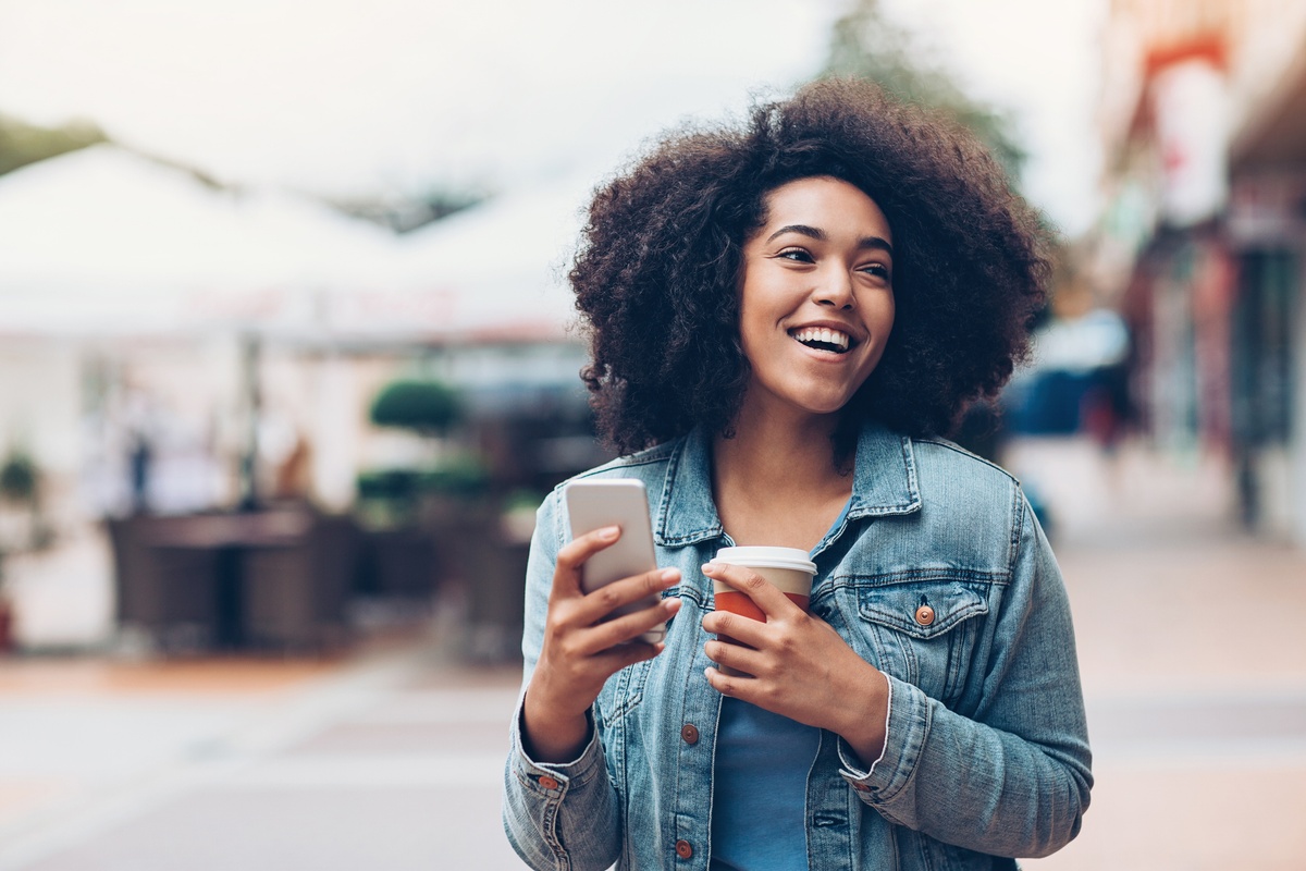 Woman holding a coffee and mobile phone