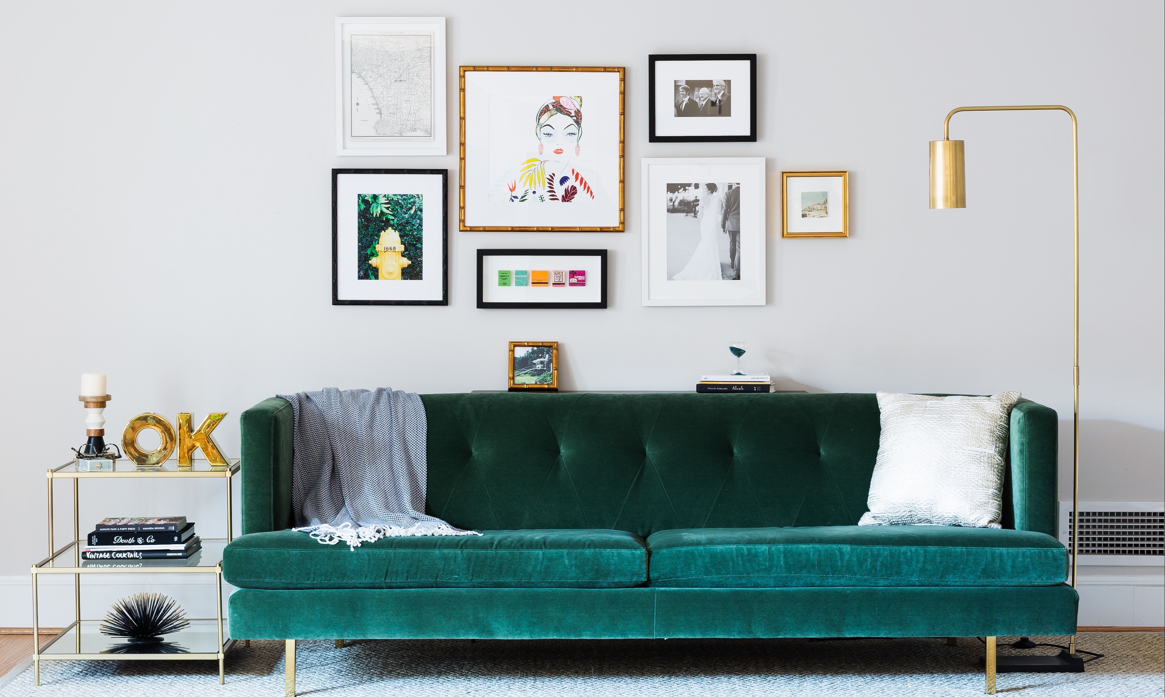 gallery wall above green velvet couch