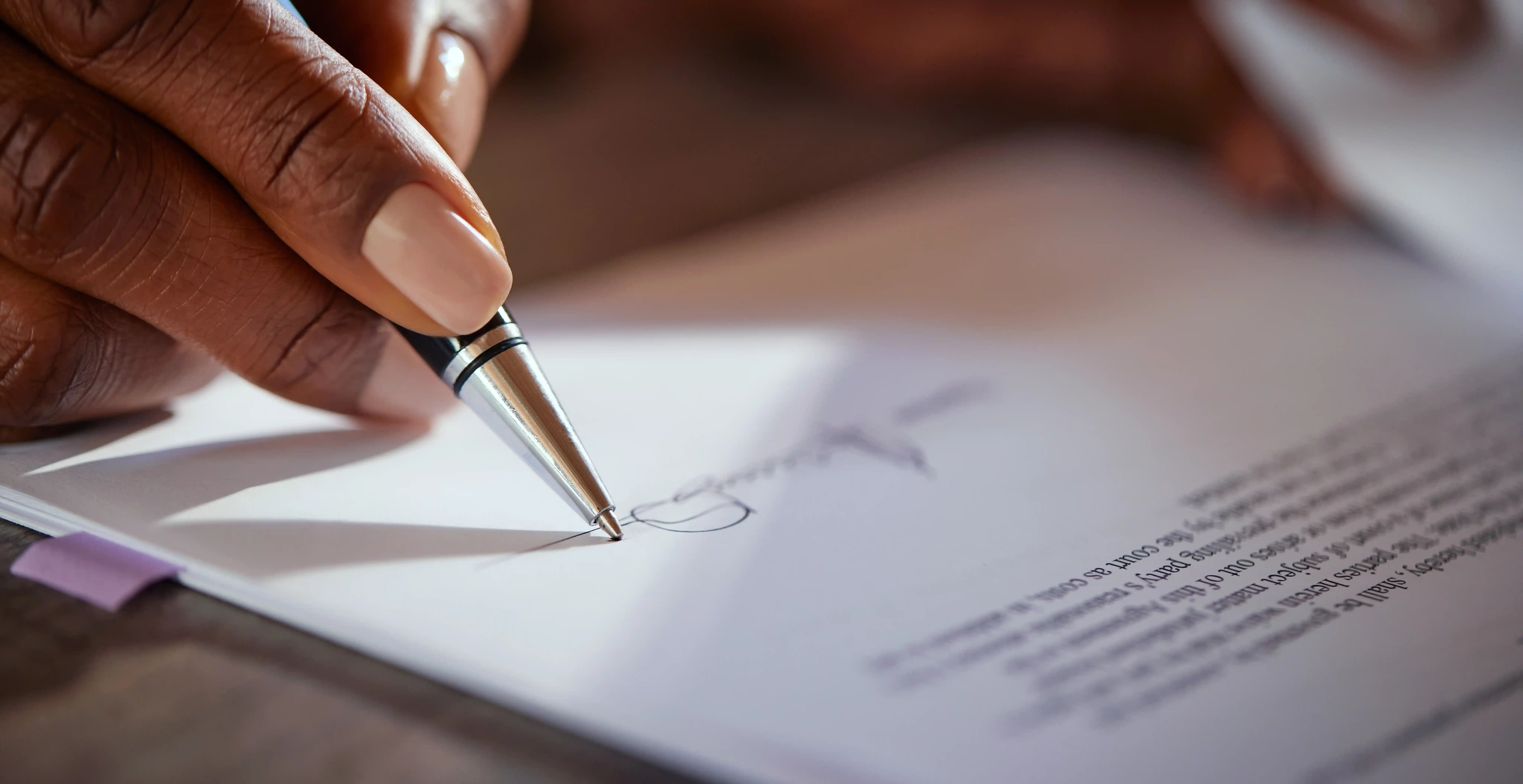 Hand signing international business contract representing ESG governance compliance and legal transparency