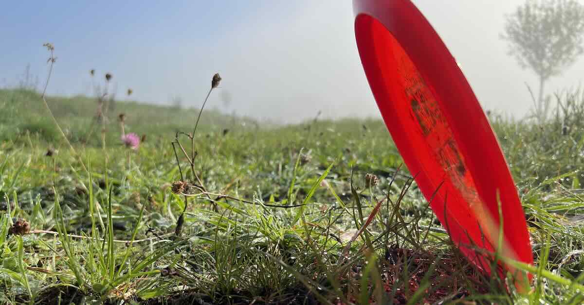 A disc golf disc on the ground on a roller angle