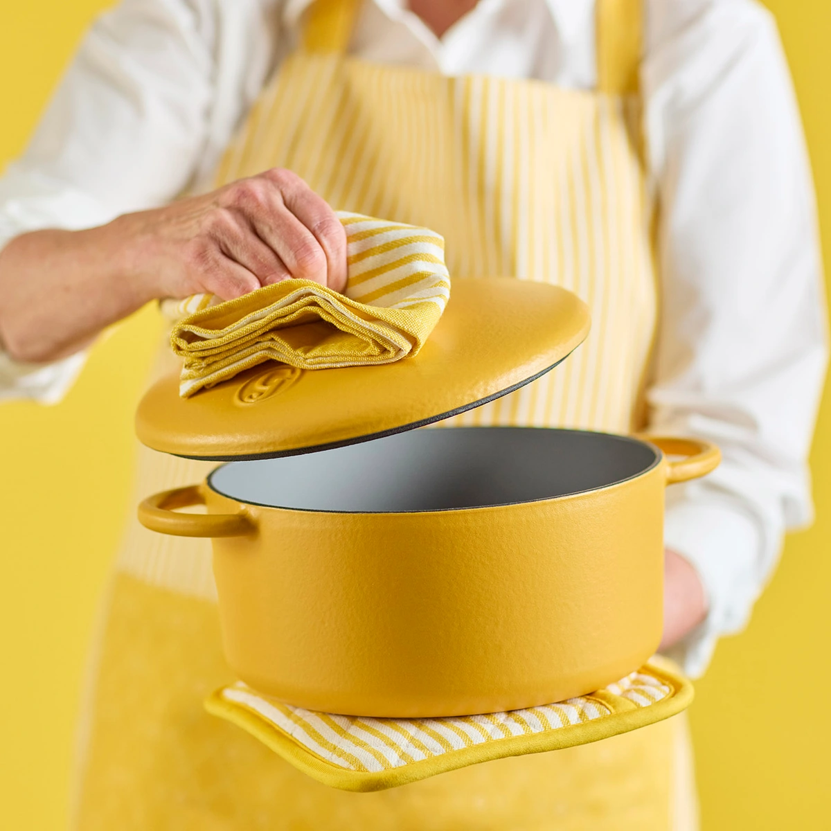 Woman holding a yellow dutch oven 