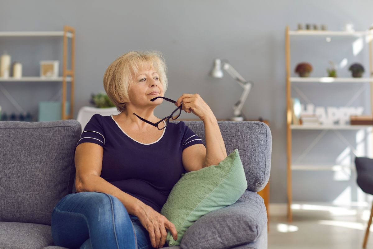 Woman sitting on couch, considering a Medicare Advantage plan