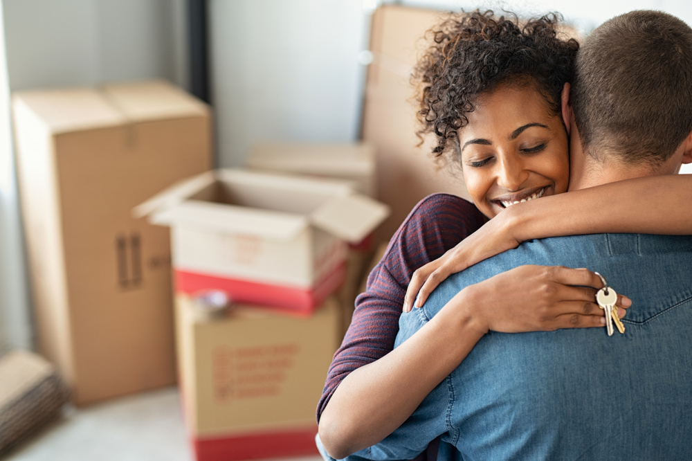 couple hugging with house keys in hand