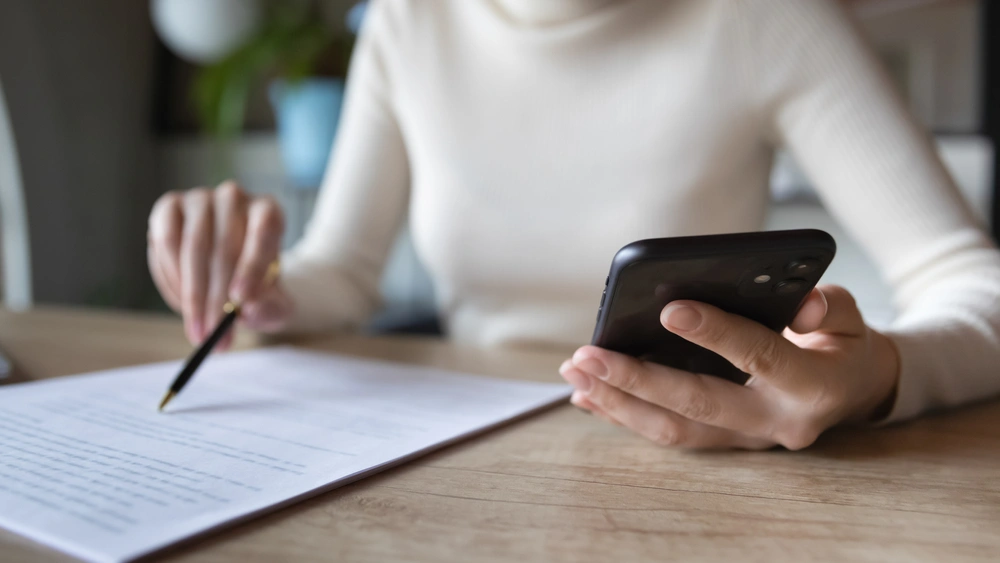 person using mobile and reading document