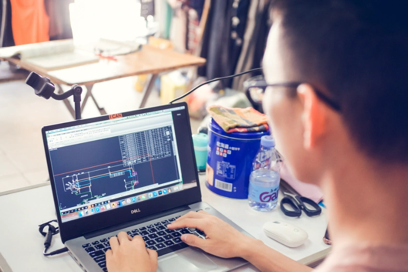 A man working on AutoCAD on a laptop