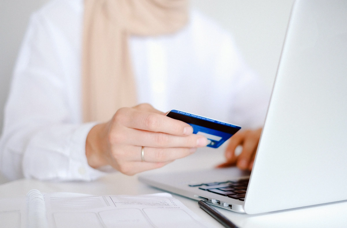 Woman with credit card on laptop