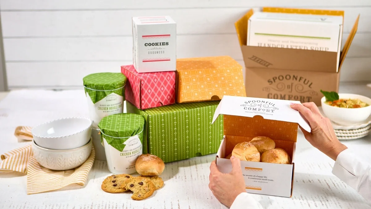 Spoonful of Comfort gift display featuring soup, rolls, cookies, and regular gift boxes flipped inside out to showcase their colorful yellow, green, and red interior patterns.
