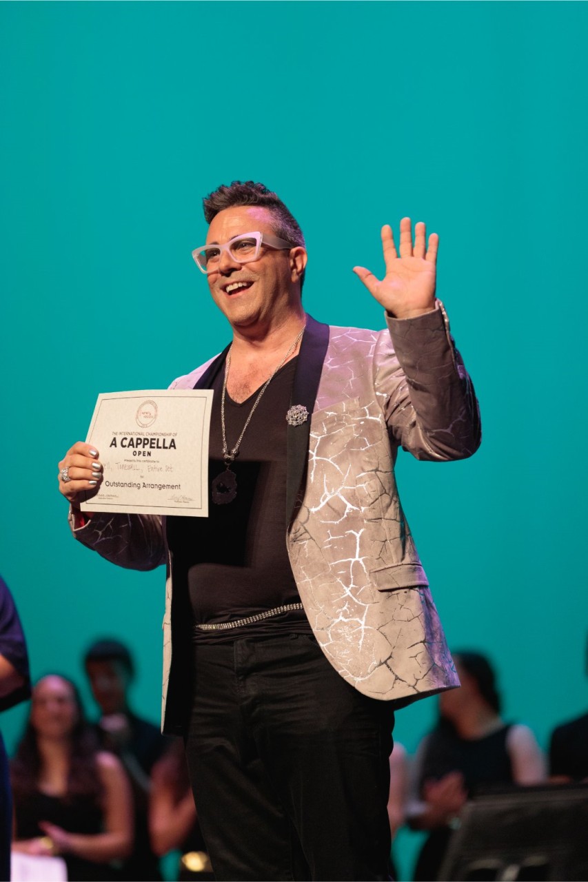 man on stage with award