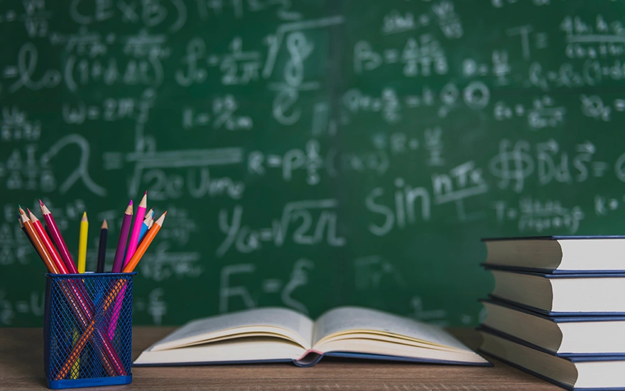 Books and blackboard on wooden background.