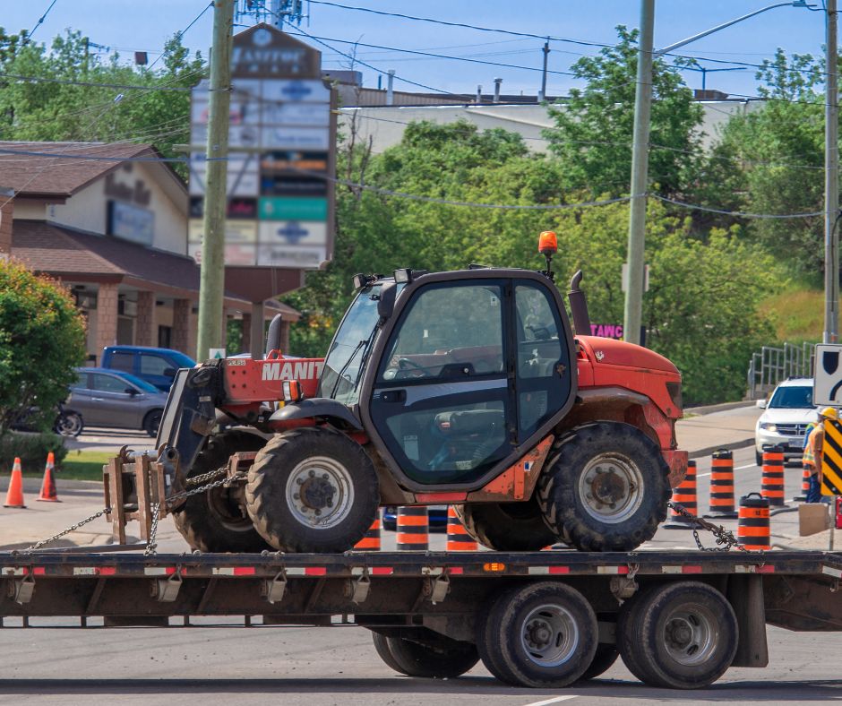Manitou telehandler being hauled to a construction site