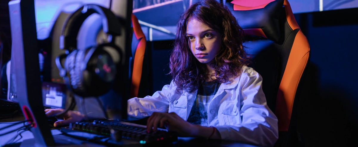 Teenager sat at a desk playing video games with a serious face. Community Fibre explains the difference between Ping, Jitter and latency, and how it can affect your gaming experience.