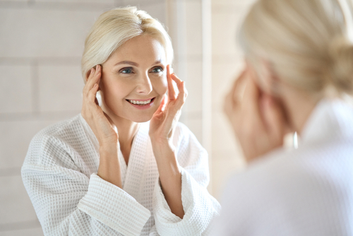 A woman examining her skin in the mirror