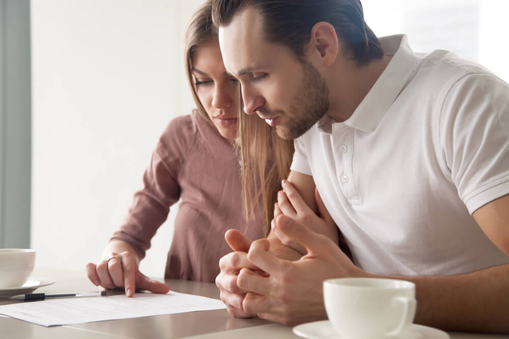 Couple reading paper on How Loans Affect Credit Score
