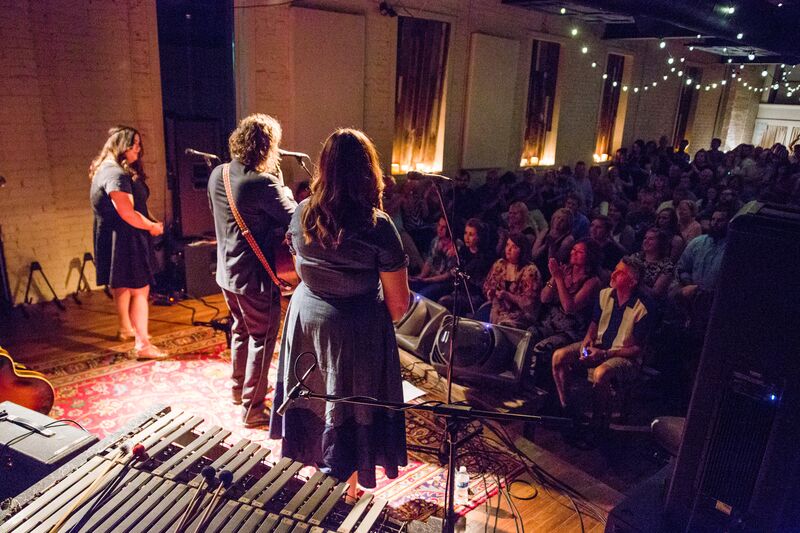 People singing on stage to an audience