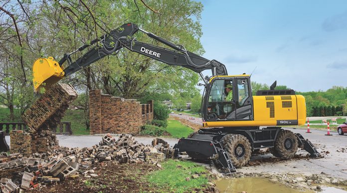 John Deere wheeled excavator demolishing a brick wall