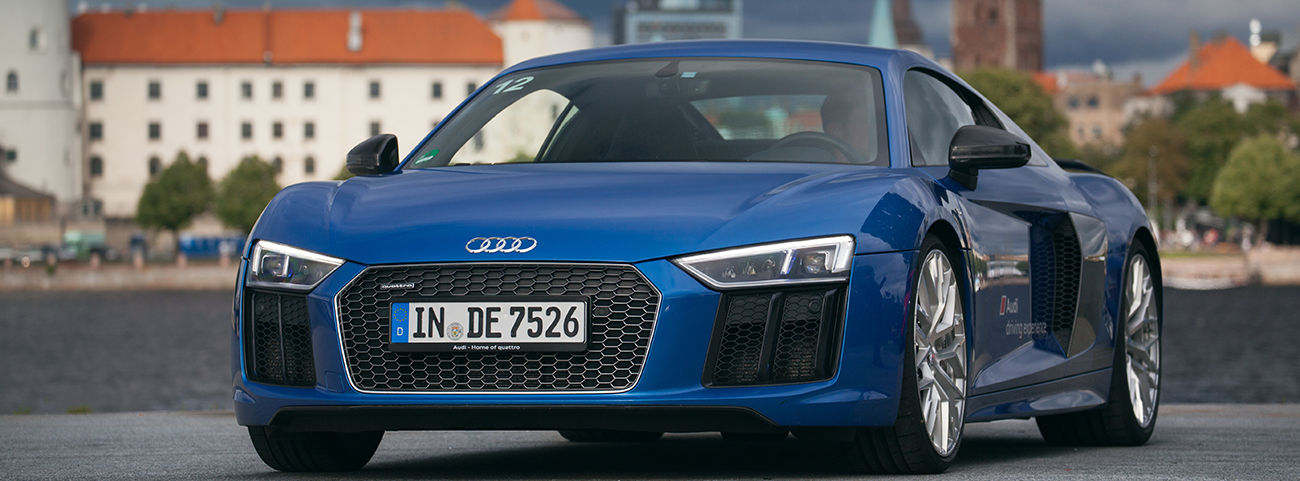 Audi R8 azul estacionado frente en clima lluvioso