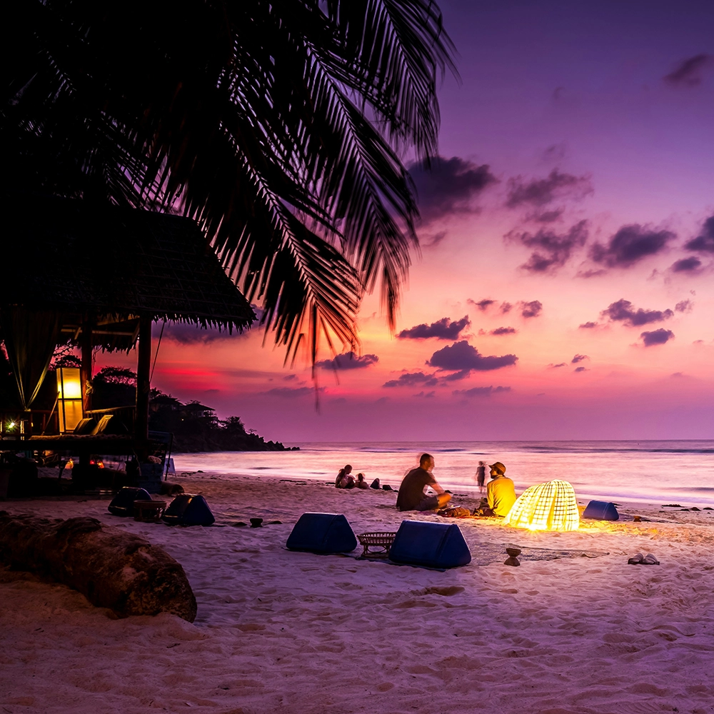 Beach goers watching sunset.webp