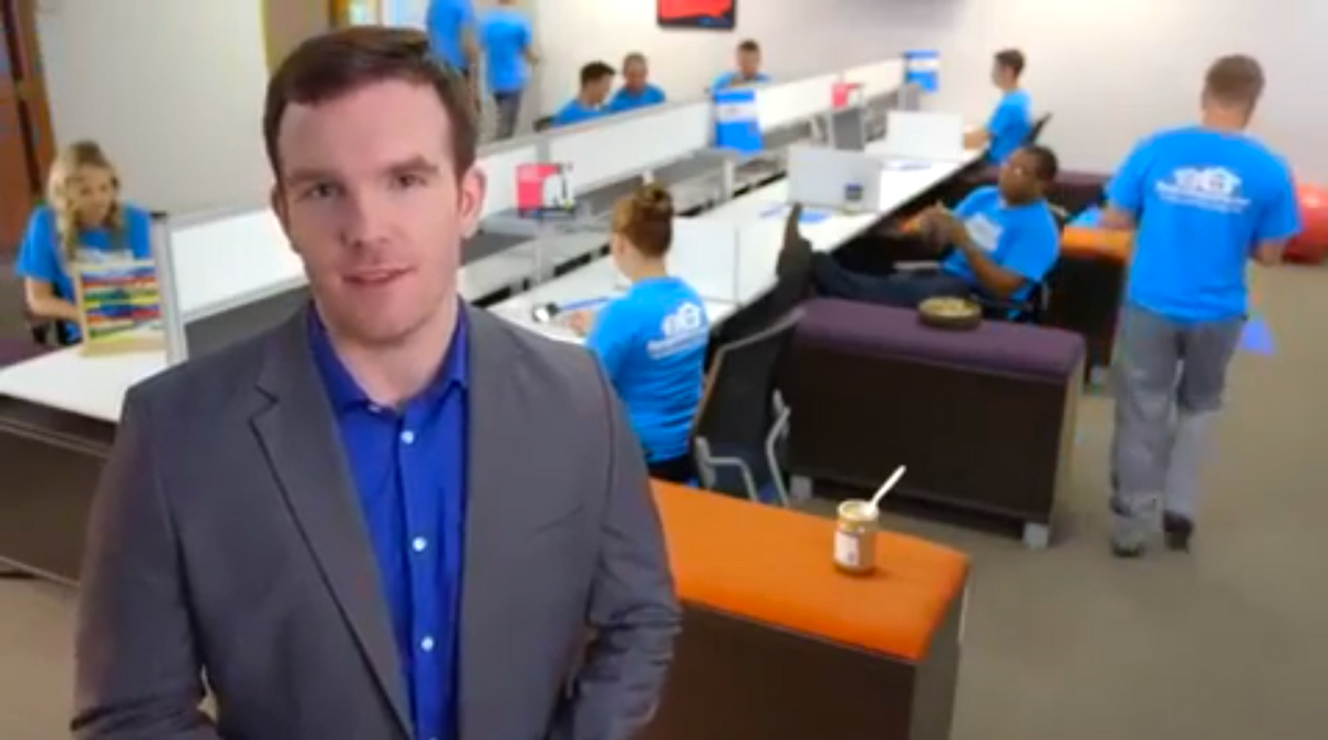 People in blue t-shirts with white RW logo working in office