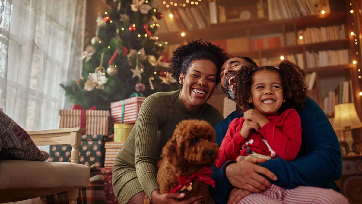 A family smiles around a Christmas tree after they earn extra Christmas money from receive a payday loan.