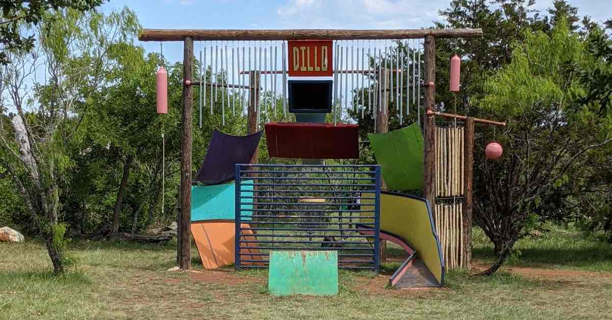 An interesting barrier of multicolored metal guards a disc golf basket