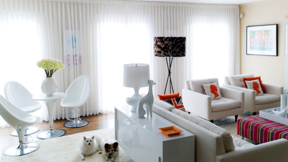 Living room with white furniture and red and orange accents