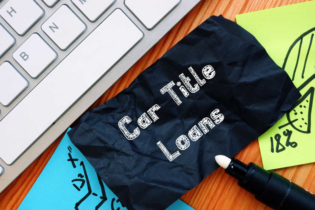 A black note next to a keyboard displays car title loans in white text.