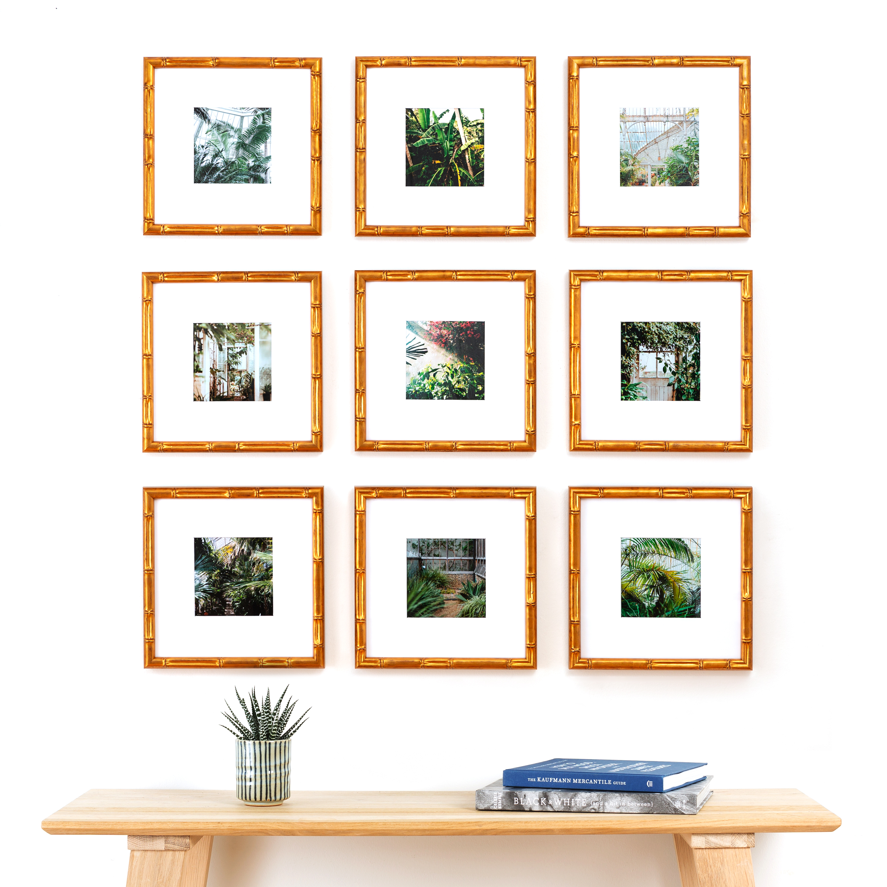 9 picture frames in a grid gallery wall above a table