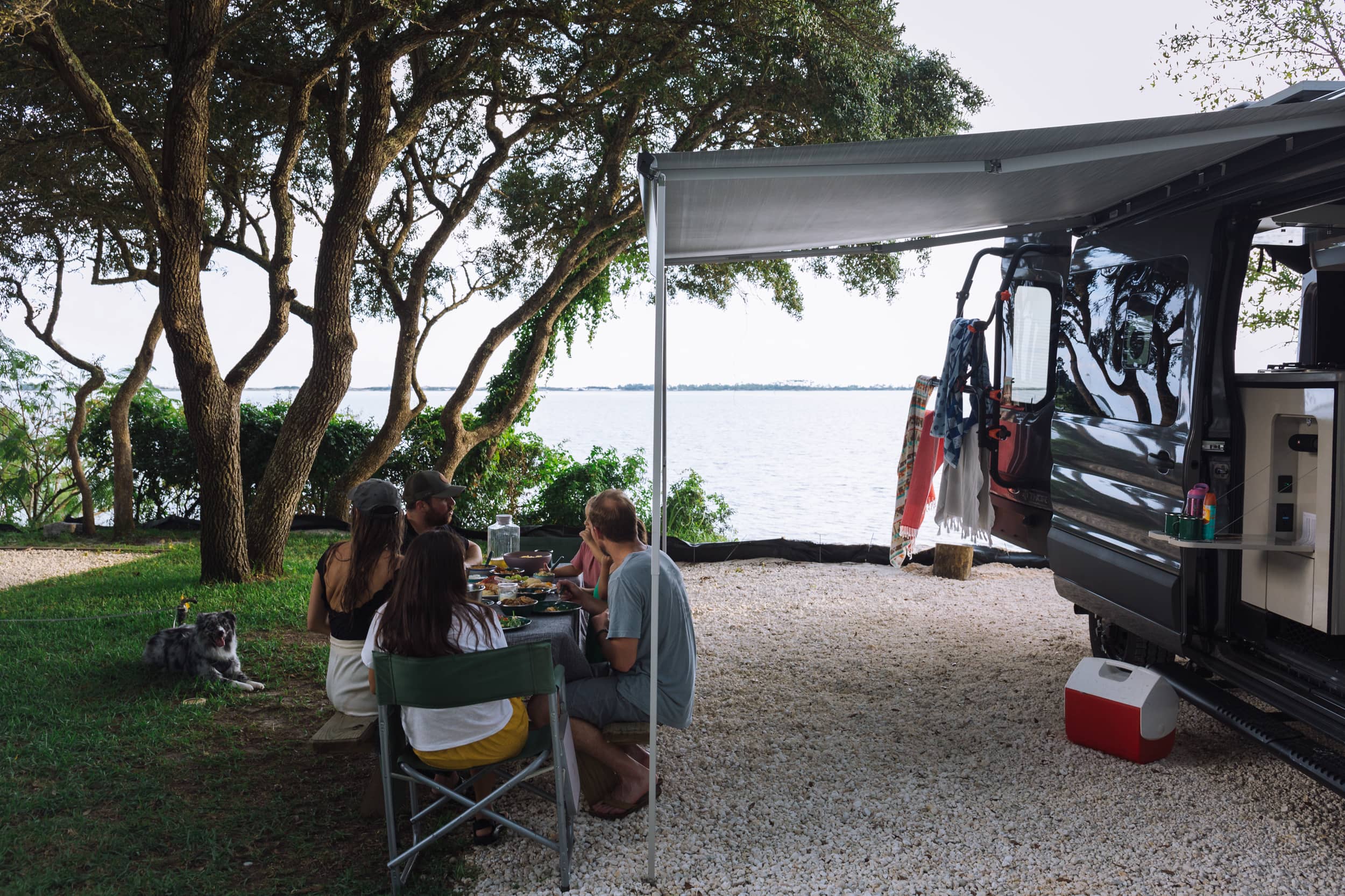 families eating by camper at campground