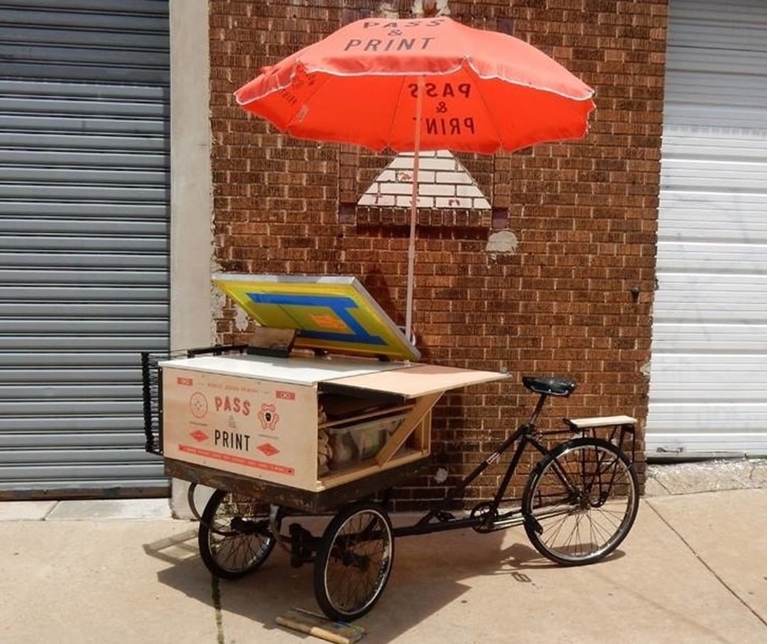 A screen printing setup on a three-wheeled bicycle