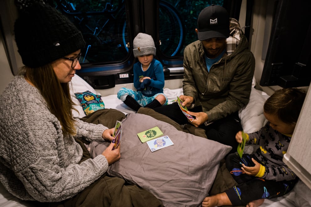 family playing cards inside RV during winter