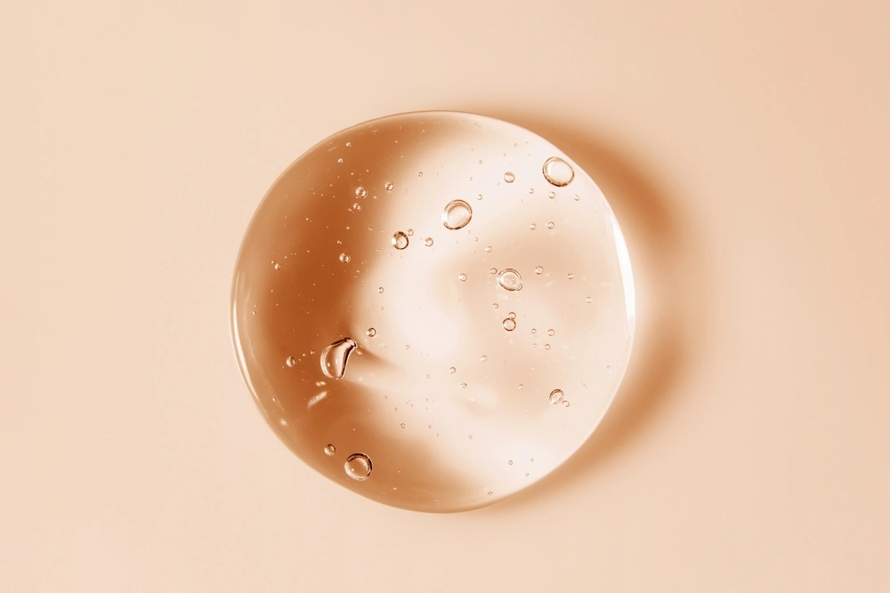 A drop of serum on a beige background