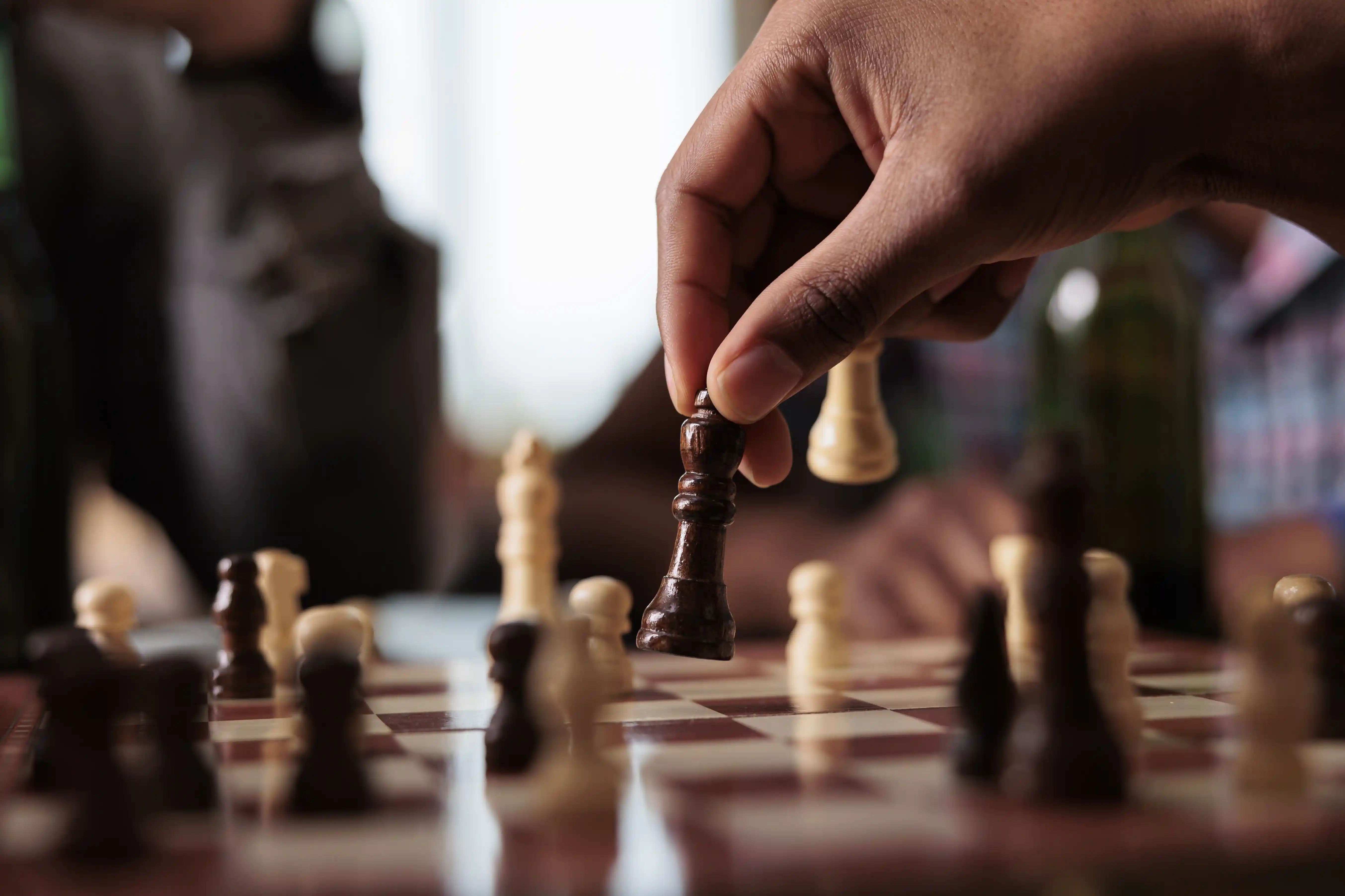 Hand moving chess piece symbolizing strategic decision-making in business scaling