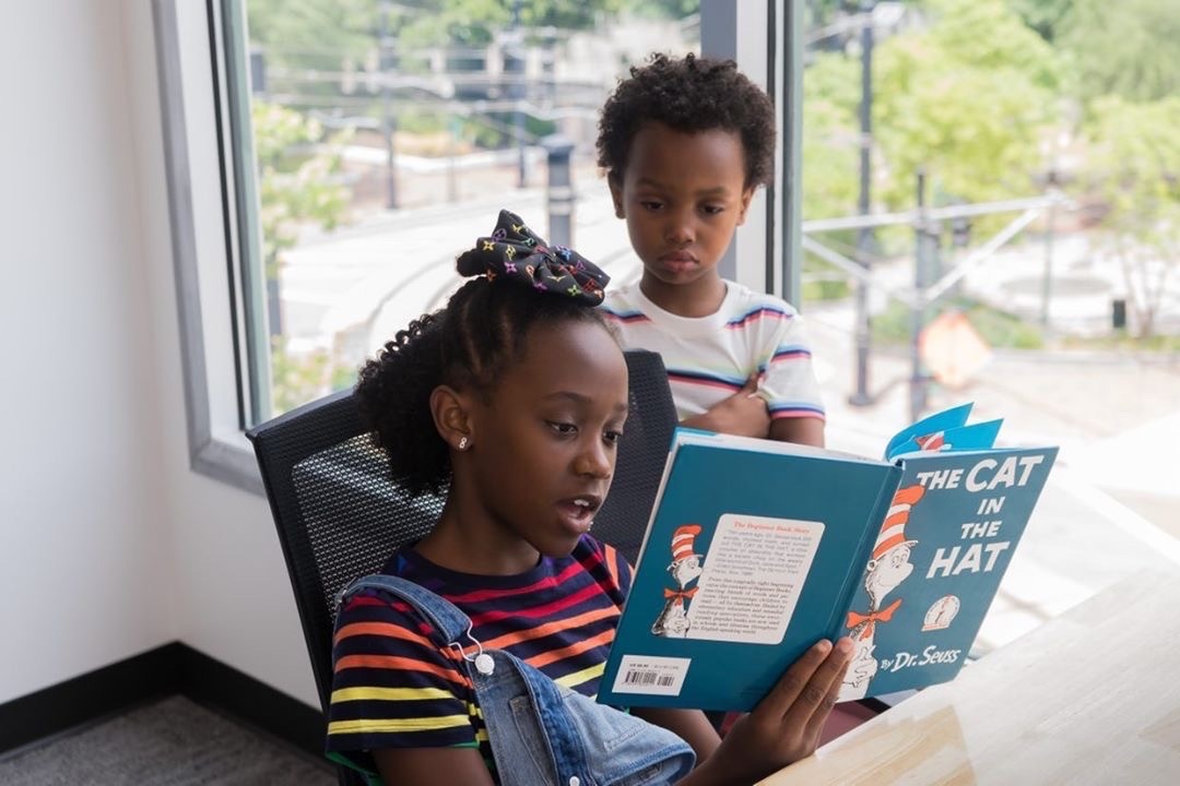 kids reading a book in primary t-shirts