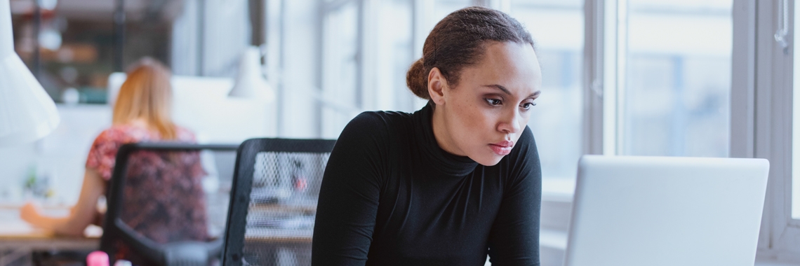 A woman staring at her computer screen.