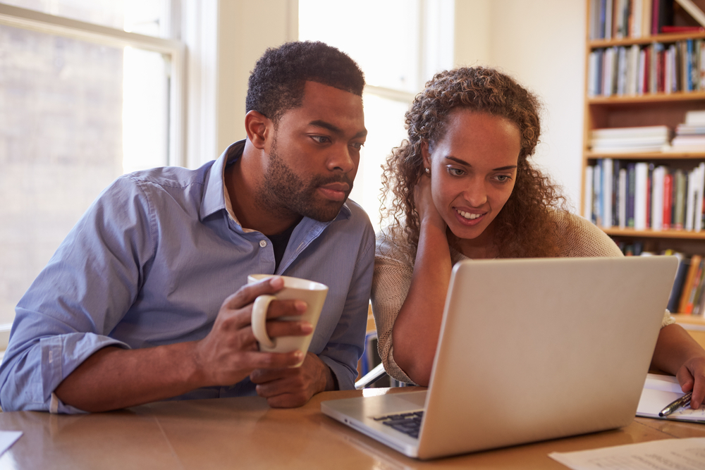couple reading on laptop